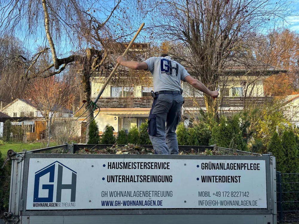 GH-Mitarbeiter verteilt Grünschnitt auf dem beschrifteten Anhänger